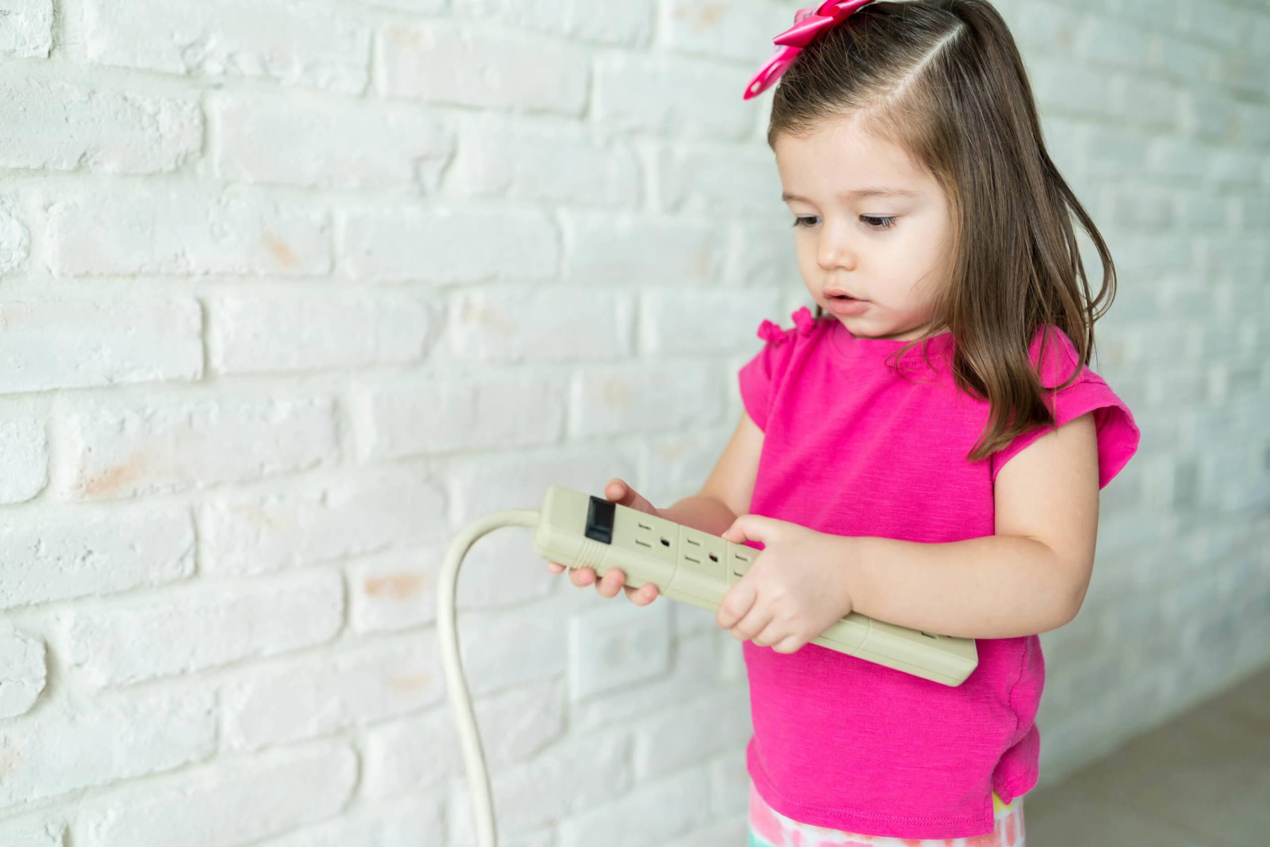 Girl-Looking-At-extension-cord-safety