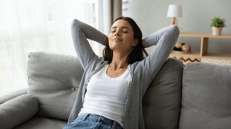 Woman relaxing on grey sofa